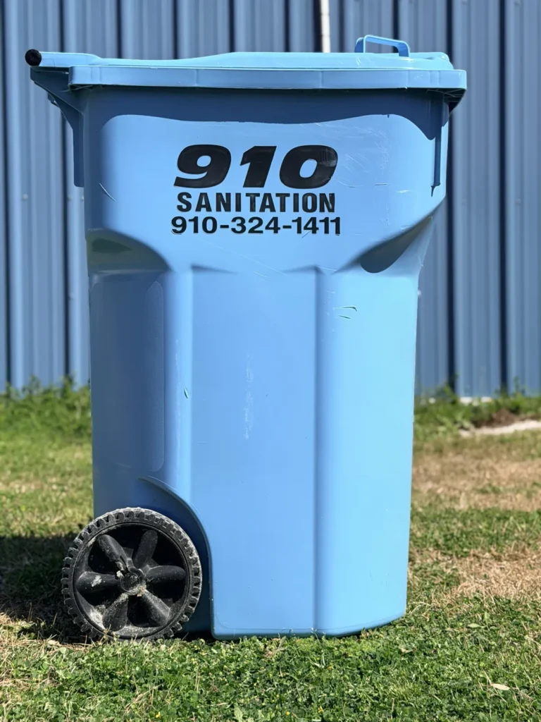 910 Sanitation branded blue trash can at the curb