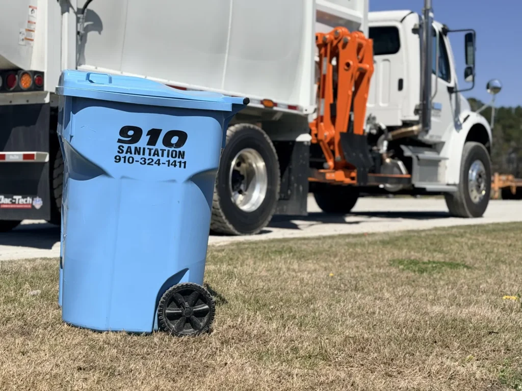 910 Sanitation truck picking up a blue trash can